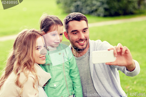 Image of happy family taking selfie by smartphone outdoors