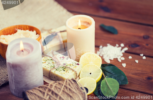 Image of close up of natural soap and candles on wood