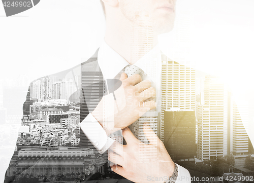 Image of close up of man adjusting his tie