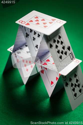 Image of close up of house of playing cards on green cloth