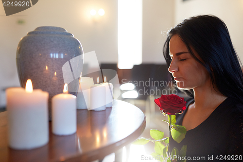 Image of woman with rose and funerary urn at church