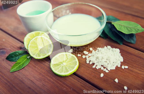 Image of close up of body lotion, cream and salt on wood