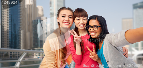 Image of international happy women taking selfie in city