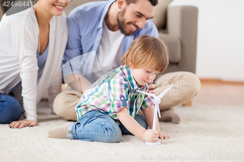 Image of happy family playing with toy wind turbine