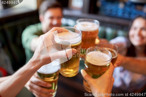 Image of happy friends drinking beer at bar or pub