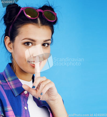 Image of young pretty teenage modern hipster girl posing emotional happy smiling on blue background, lifestyle people concept
