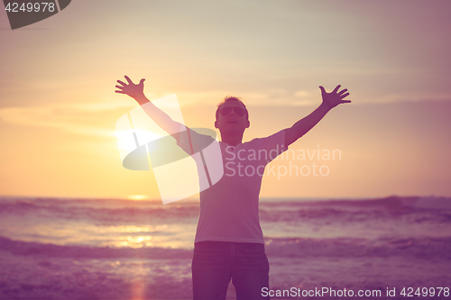 Image of happy man standing on the beach