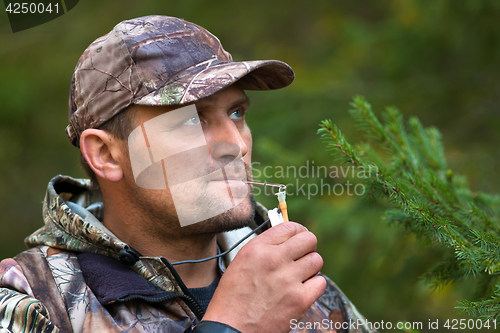 Image of hunter with a grouse call in the forest