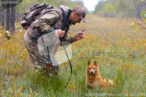 Image of hunter with dog on the swamp