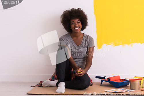 Image of back female painter sitting on floor