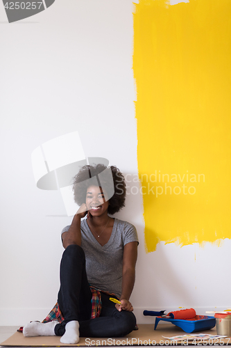 Image of back female painter sitting on floor