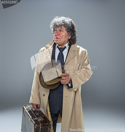 Image of The senior man as detective or boss of mafia on gray studio background