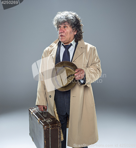 Image of The senior man as detective or boss of mafia on gray studio background