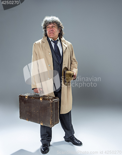 Image of The senior man as detective or boss of mafia on gray studio background