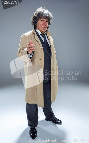 Image of The senior man as detective or boss of mafia on gray studio background