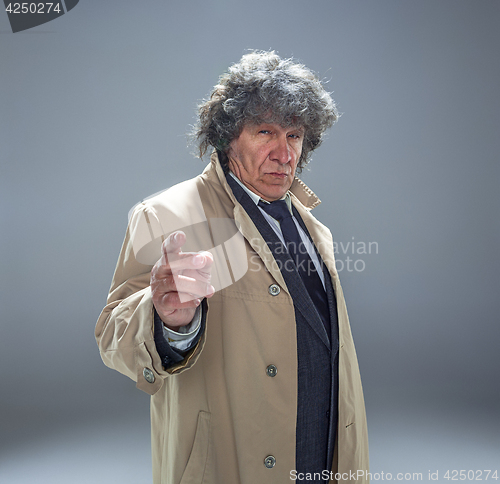 Image of The senior man as detective or boss of mafia on gray studio background