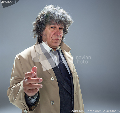 Image of The senior man as detective or boss of mafia on gray studio background