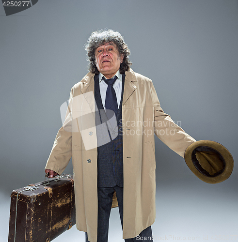 Image of The senior man as detective or boss of mafia on gray studio background