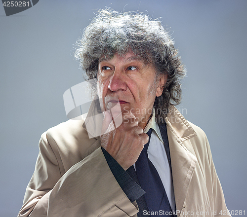 Image of The senior man as detective or boss of mafia on gray studio background