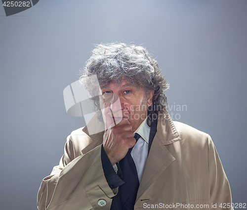 Image of The senior man as detective or boss of mafia on gray studio background