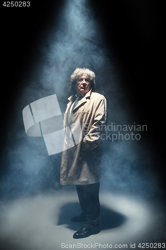 Image of The senior man as detective or boss of mafia on gray studio background