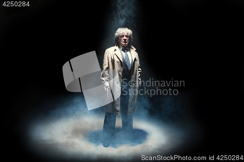 Image of Senior police agent with a gun on dark smoke background