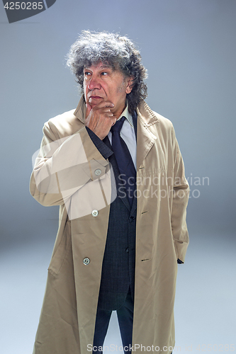 Image of The senior man as detective or boss of mafia on gray studio background