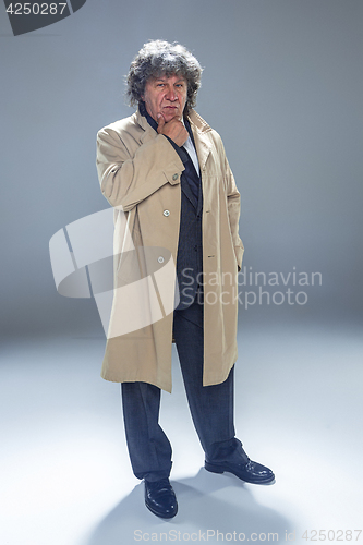 Image of The senior man as detective or boss of mafia on gray studio background