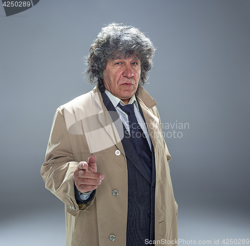 Image of The senior man as detective or boss of mafia on gray studio background