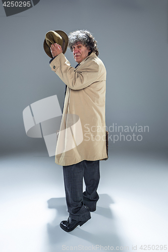 Image of The senior man as detective or boss of mafia on gray studio background