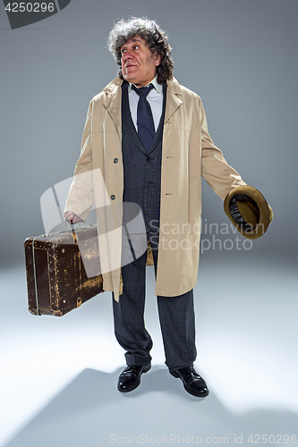 Image of The senior man as detective or boss of mafia on gray studio background