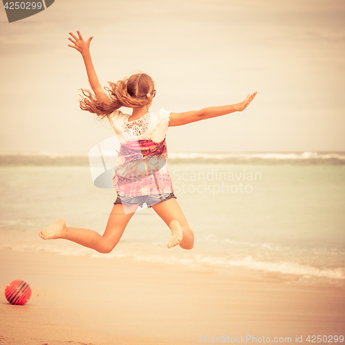 Image of Happy teen girl  jumping on the beach