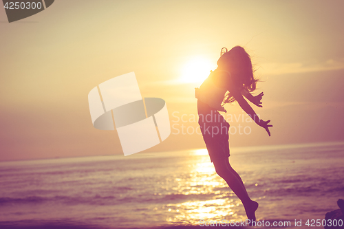 Image of Happy little girl  jumping on the beach