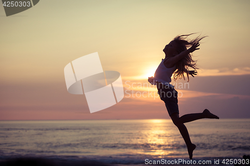 Image of Happy little girl  jumping on the beach