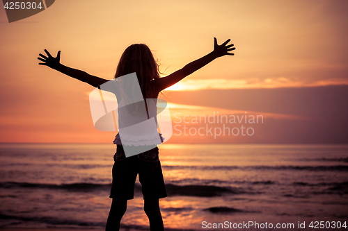 Image of Happy little girl  standing on the beach