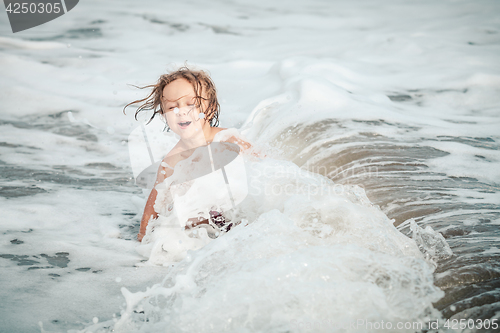 Image of Portrait of little boy standing on the beach