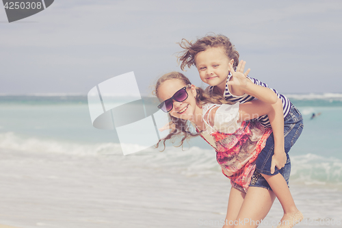 Image of Sister and brother playing on the beach at the day time.