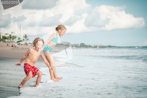 Image of Sister and brother playing on the beach at the day time.