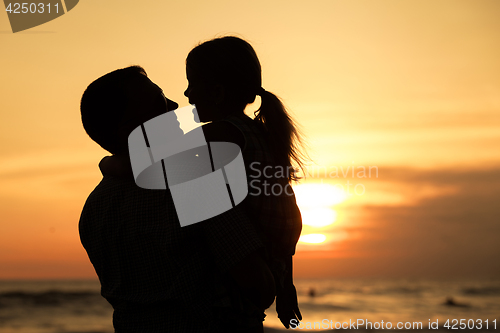 Image of Father and daughter playing on the beach at the day time.