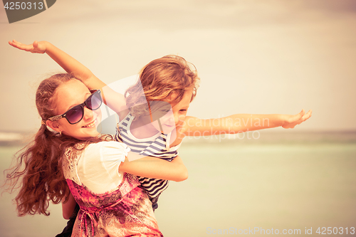 Image of Sister and brother playing on the beach at the day time.