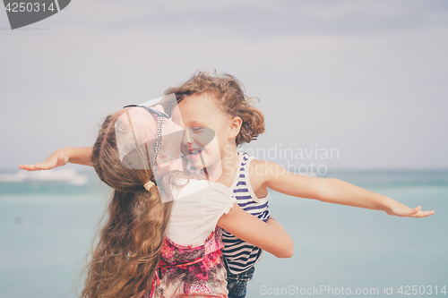 Image of Sister and brother playing on the beach at the day time.