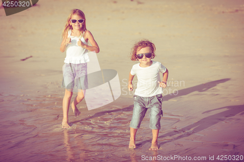 Image of Sister and brother playing on the beach at the day time.