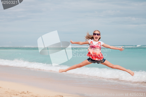 Image of Happy teen girl  jumping on the beach