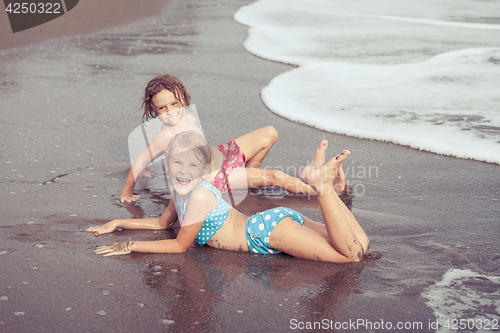 Image of Sister and brother playing on the beach at the day time.