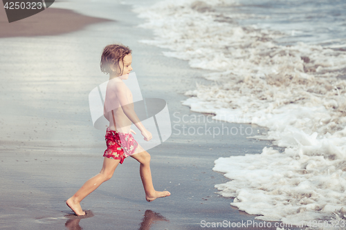 Image of Portrait of little boy standing on the beach