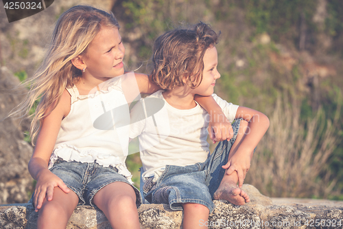 Image of Sister and brother playing on the beach at the day time.