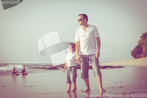 Image of Father and son playing on the beach at the day time.