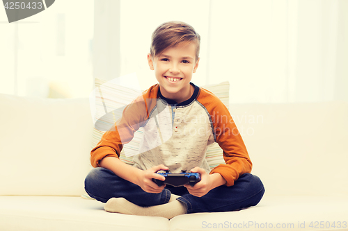 Image of happy boy with joystick playing video game at home