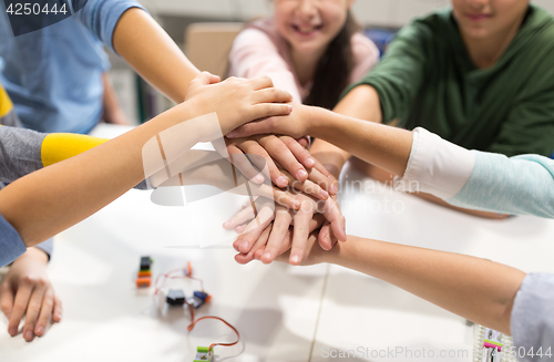 Image of happy children holding hands at robotics school