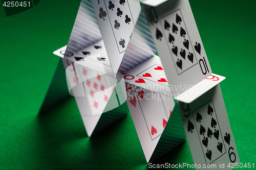 Image of close up of house of playing cards on green cloth